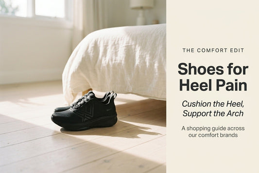 black supportive shoes for heel pain on a bedroom floor beside a bed, from The Comfort Co